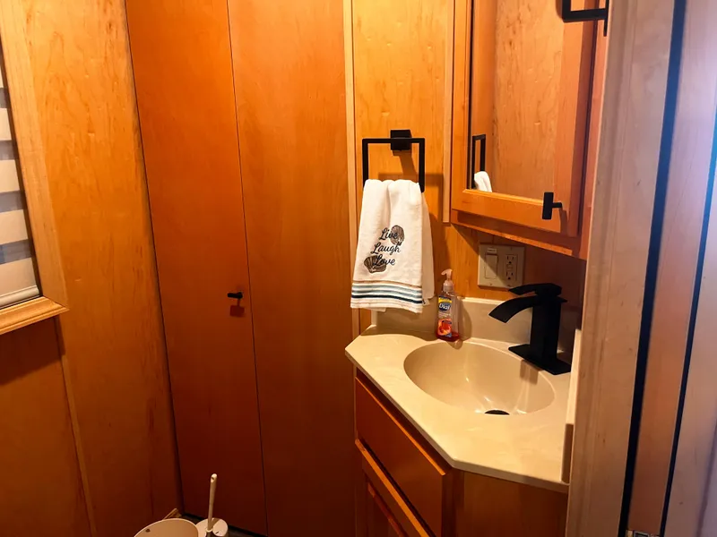 Slide: The Image of Compact bathroom in a 2004 Starlight 68X16 model with wooden cabinets and modern fixtures. - 19