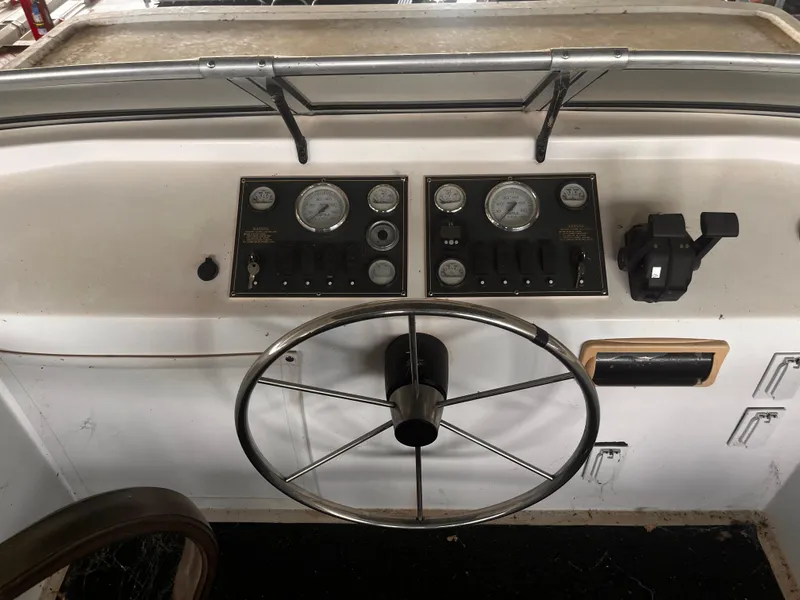 Slide: The Image of Control panel of a 2004 Starlight 68X16 boat with steering wheel and gauges. - 29