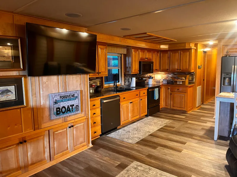 Slide: The Image of Modern kitchen in a 2004 Starlight 68X16 houseboat with wooden cabinets and stainless steel appliances. - 4