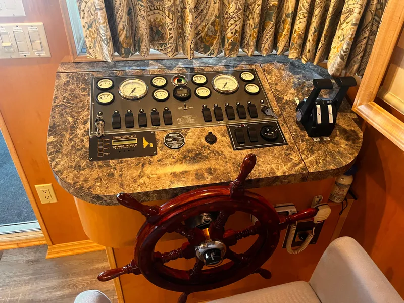 Slide: The Image of Control panel of a 2004 Starlight 68X16 boat with steering wheel and gauges. - 5