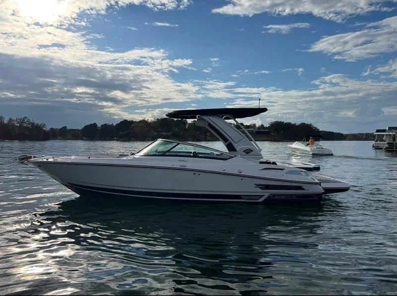 Slide: The Image of 2023 Monterey 298SS boat on a calm lake under a partly cloudy sky. - 13