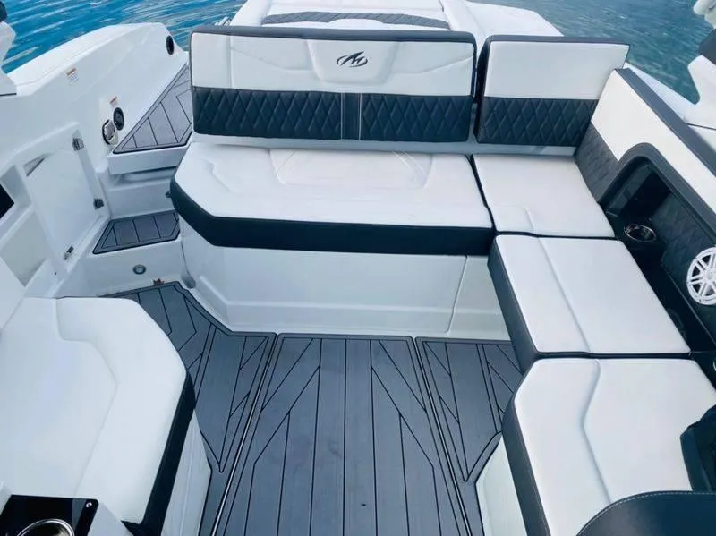 Slide: The Image of 2023 Monterey 298SS boat interior with white and black seating, gray flooring. - 5