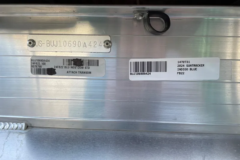 Slide: The Image of 2024 Sun Tracker Fishin' Barge 22 DLX identification tags on metal surface. - 82