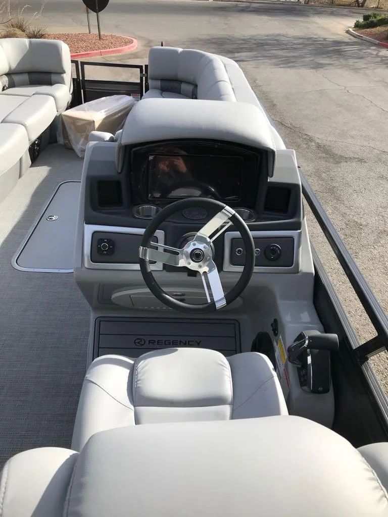 Slide: The Image of 2024 Regency 250 LE3 boat interior with steering console and seating. - 3