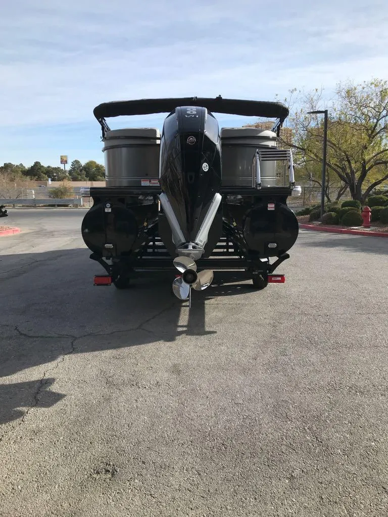 Slide: The Image of 2024 Regency 250 LE3 pontoon boat, rear view, parked outdoors. - 6
