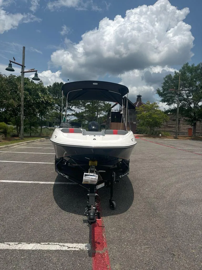 Slide: The Image of 2024 Tahoe T16 boat parked in a lot under a cloudy sky. - 3