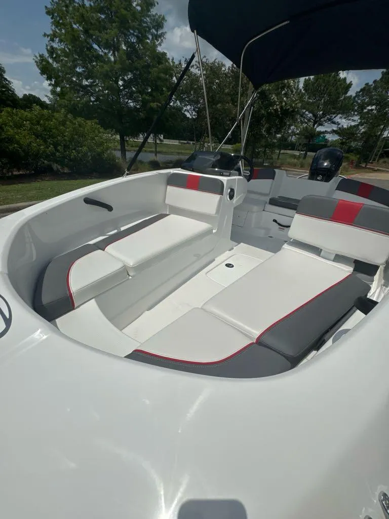 Slide: The Image of 2024 Tahoe T16 boat interior with white and gray seating, red accents, and canopy. - 4
