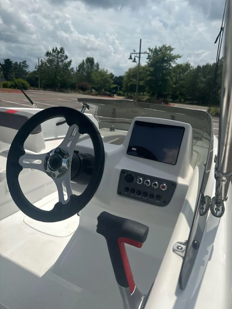 Slide: The Image of 2024 Tahoe T16 boat dashboard with steering wheel and control panel. - 7