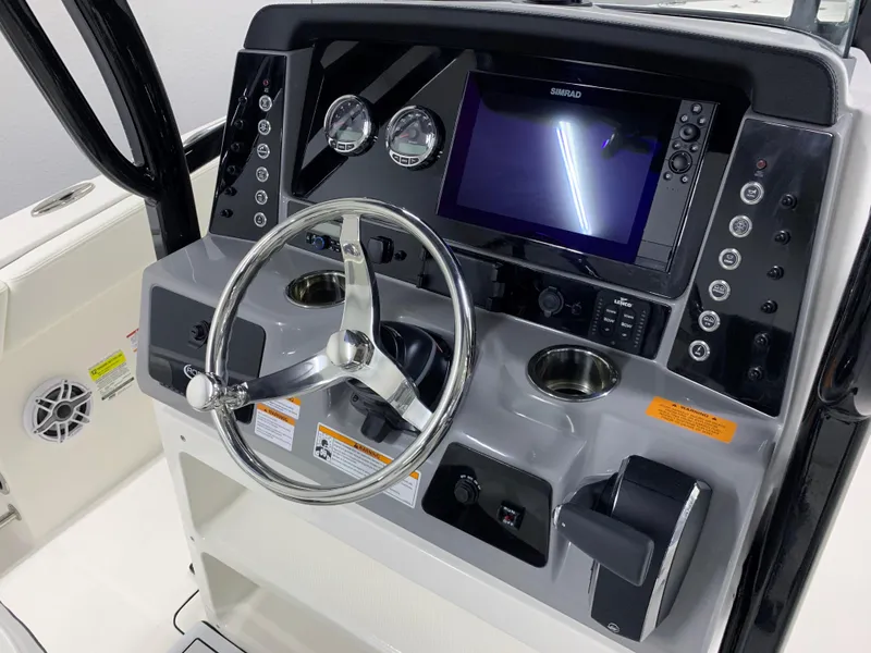 Slide: The Image of 2024 Robalo R232 Explorer boat dashboard with steering wheel and navigation system. - 20