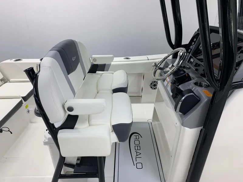 Slide: The Image of 2024 Robalo R232 Explorer boat interior with helm station and cushioned seating. - 7