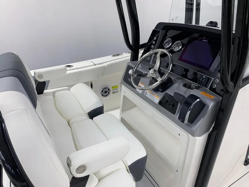 Slide: The Image of 2024 Robalo R232 Explorer boat cockpit with steering wheel and white seating. - 8