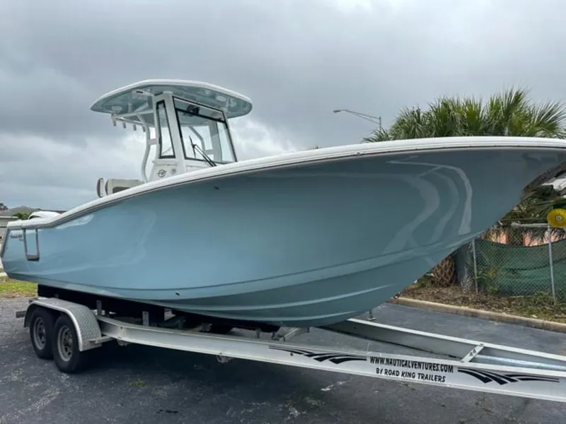 Slide: The Image of 2024 Tidewater 256 CC Adventure boat on trailer, side view. - 2