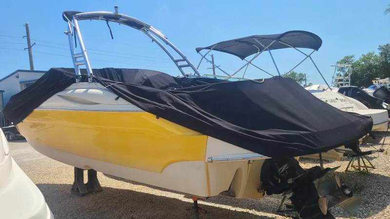 Slide: The Image of 2004 Monterey 268 SS Open Bow Sport boat with yellow hull and black cover. - 2
