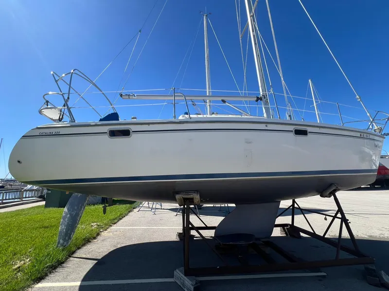 Slide: The Image of 1995 Catalina 320 sailboat on a stand, side view, clear blue sky background. - 11