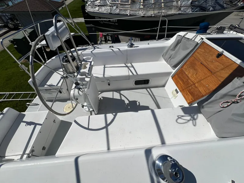 Slide: The Image of 1995 Catalina 320 sailboat cockpit with steering wheel and wooden hatch. - 32