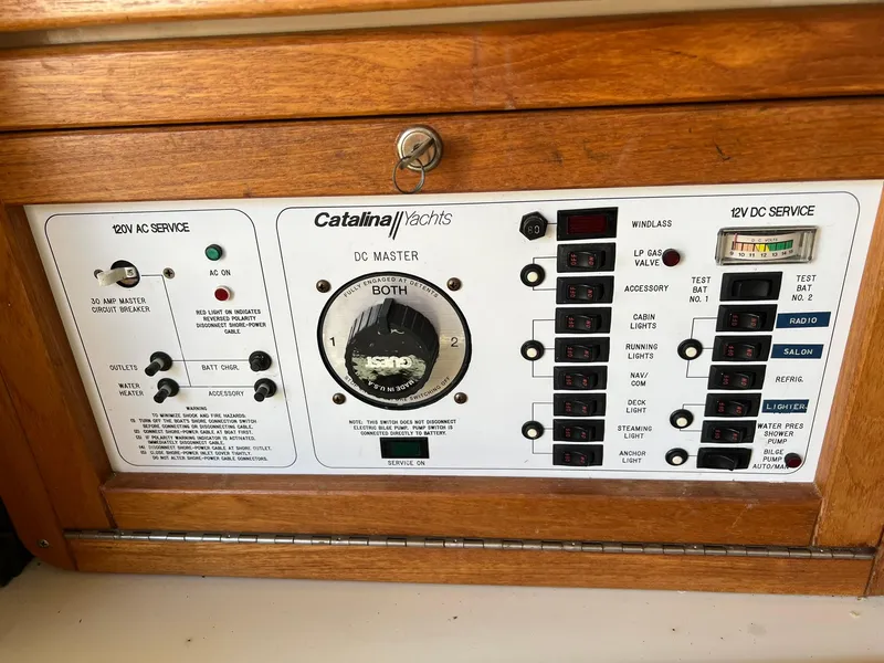 Slide: The Image of Catalina 320 1995 yacht electrical control panel with AC and DC service switches. - 35
