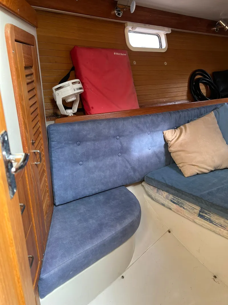 Slide: The Image of Interior of a 1995 Catalina 320 sailboat with blue seating and wooden paneling. - 36