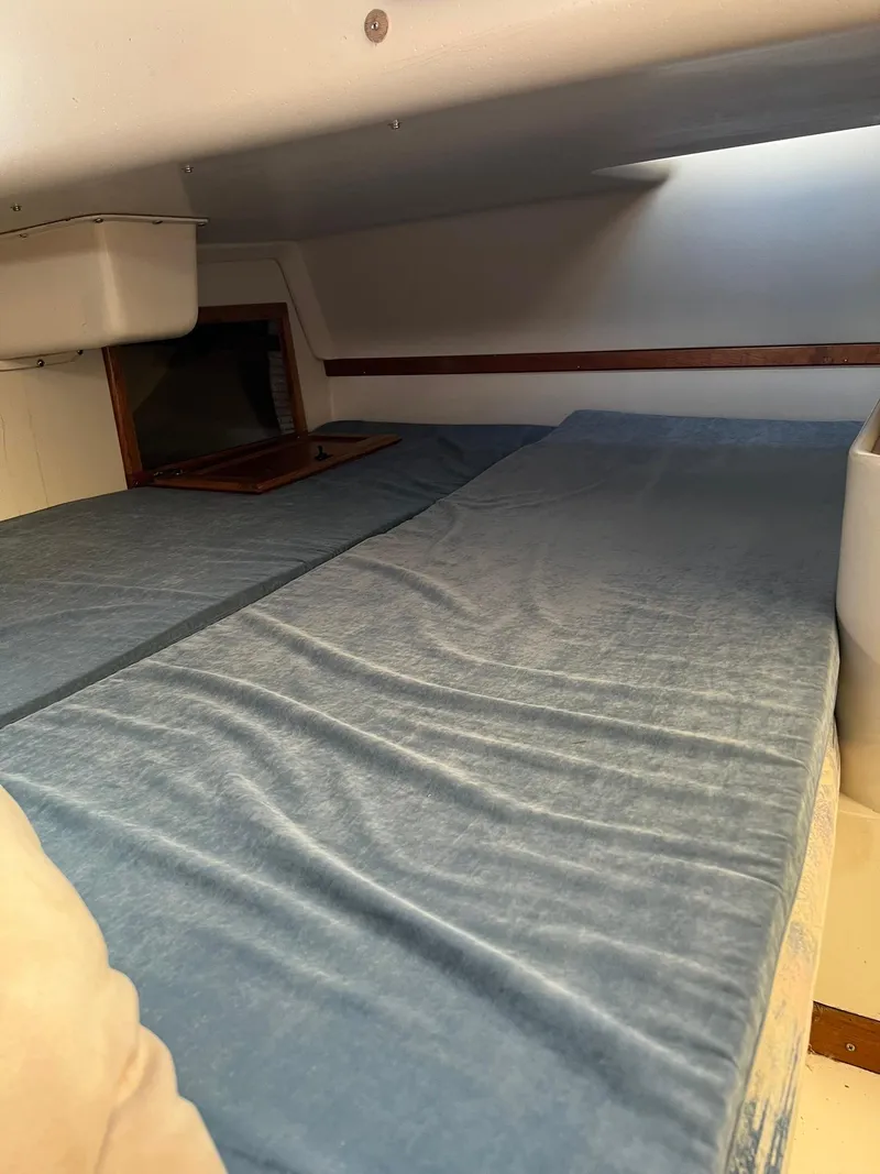 Slide: The Image of Interior cabin bed of a 1995 Catalina 320 sailboat with blue bedding. - 38