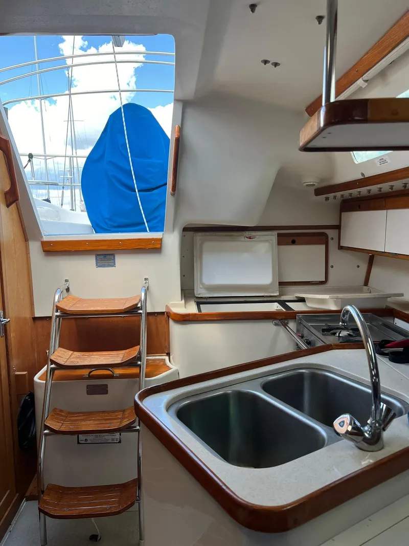 Slide: The Image of Interior of 1995 Catalina 320 sailboat with kitchen sink and steps to deck. - 41