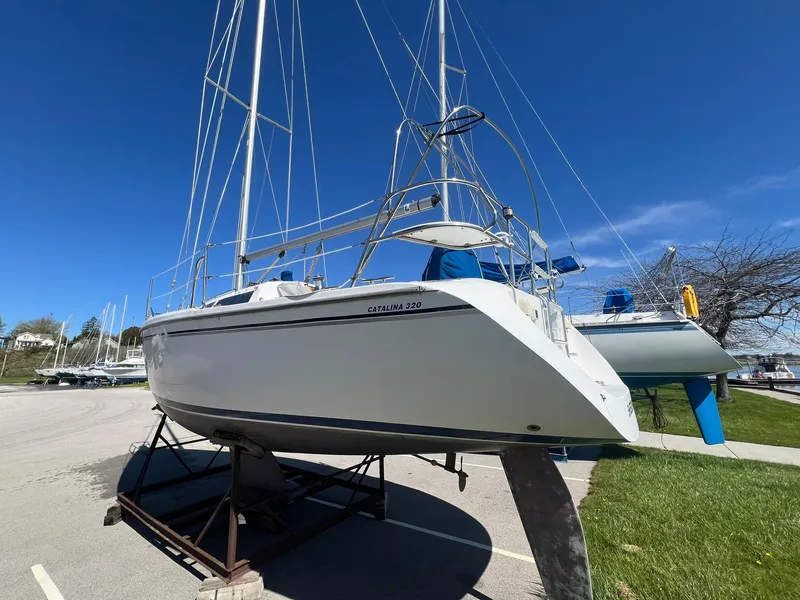 Slide: The Image of 1995 Catalina 320 sailboat on a stand under a clear blue sky. - 6