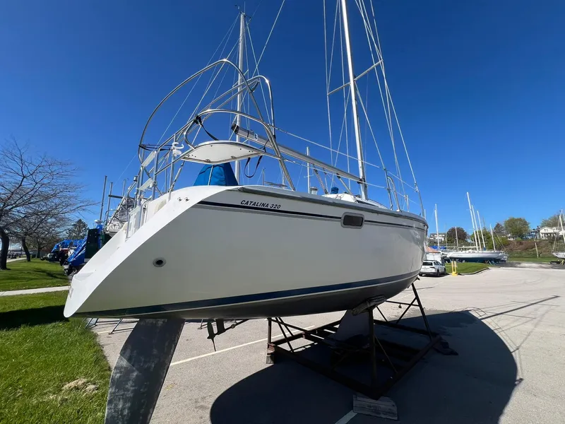 Slide: The Image of 1995 Catalina 320 sailboat on a stand in a marina, clear blue sky. - 9