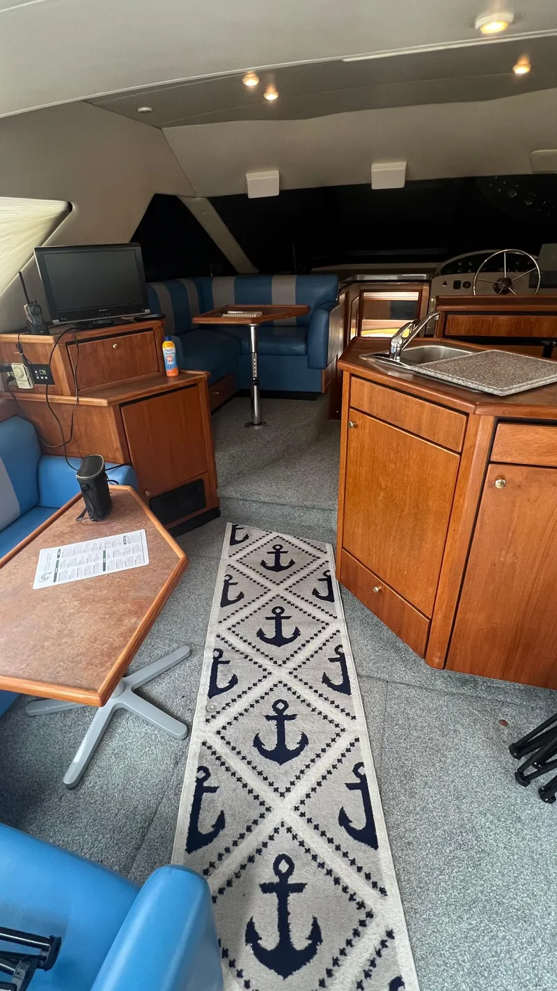 Slide: The Image of Interior of 1999 Bayliner 3988 Motoryacht with blue seating and anchor-themed decor. - 11