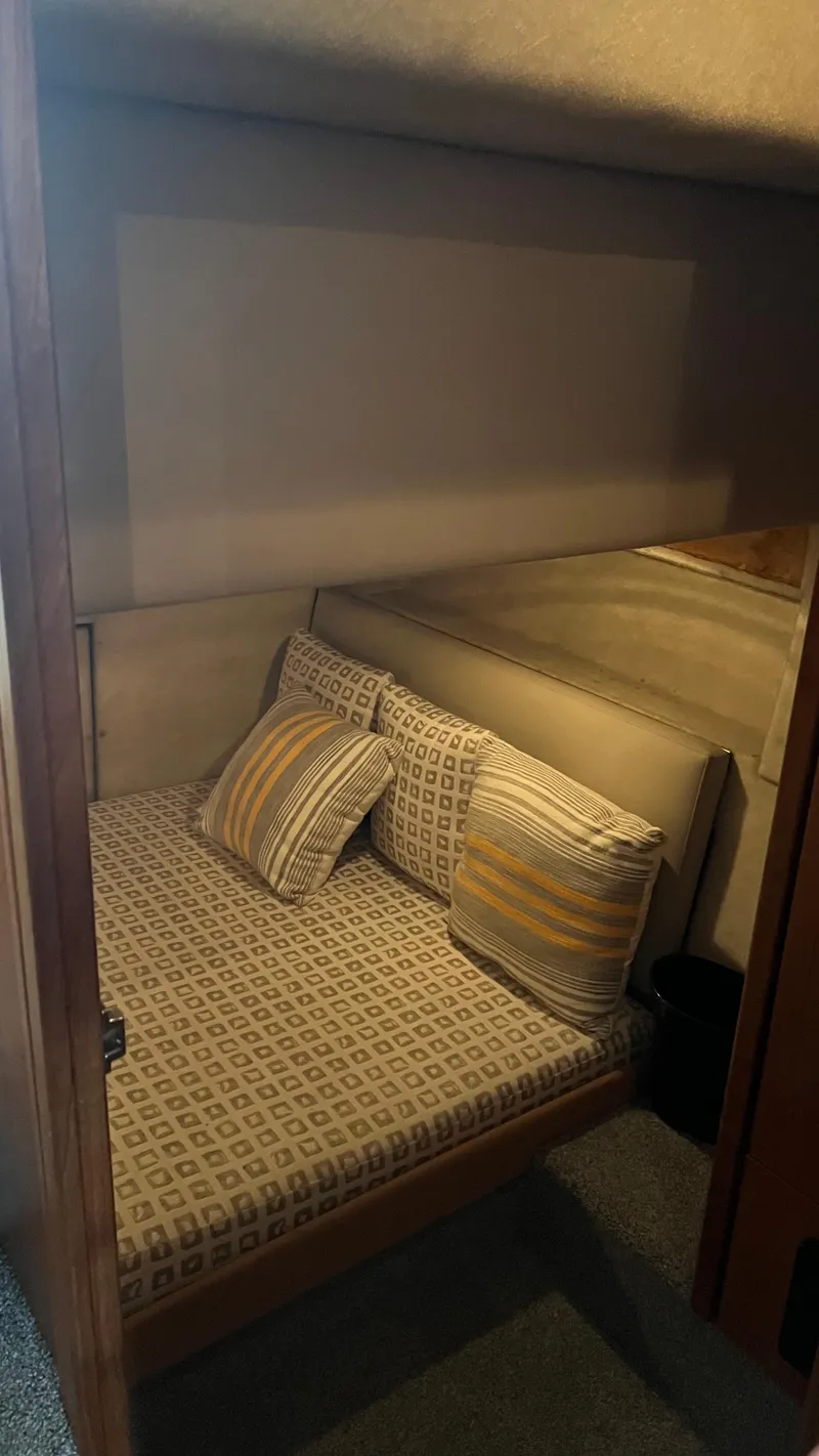 Slide: The Image of Cozy cabin interior of 1999 Bayliner 3988 Motoryacht with patterned bedding and pillows. - 20