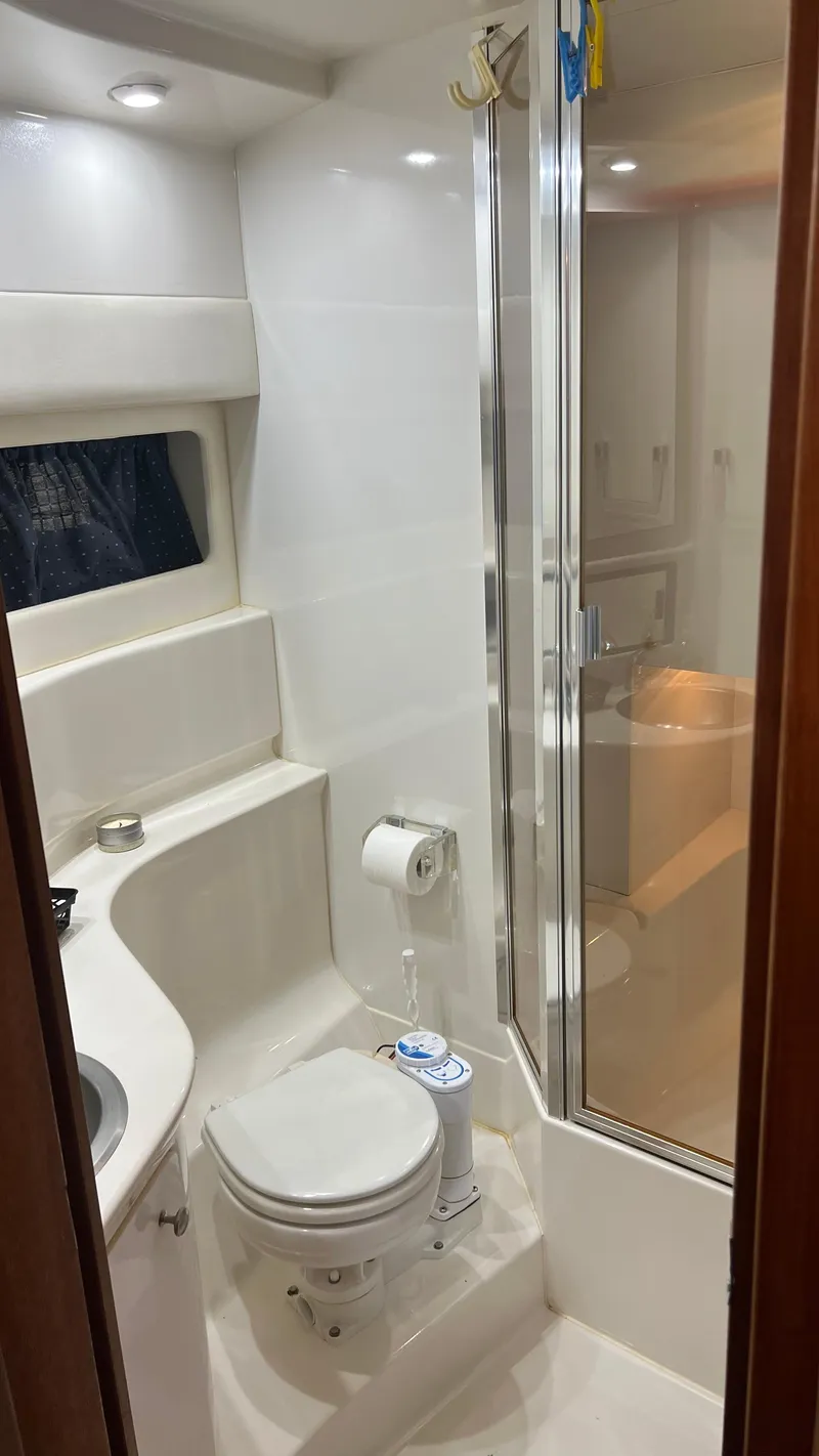 Slide: The Image of 1999 Bayliner 3988 Motoryacht bathroom with shower, toilet, and sink. - 21