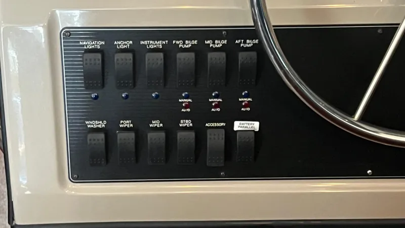 Slide: The Image of Control panel of a 1999 Bayliner 3988 Motoryacht with various switches and steering wheel. - 25
