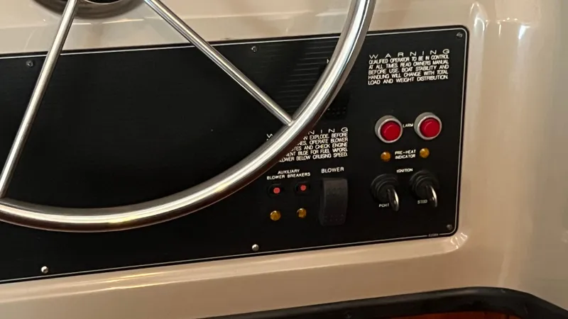 Slide: The Image of Control panel of a 1999 Bayliner 3988 Motoryacht with steering wheel and warning labels. - 26