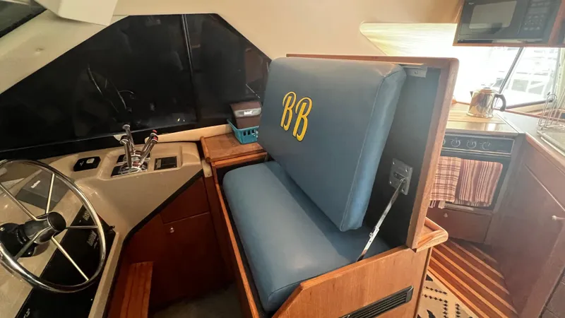 Slide: The Image of Interior of 1999 Bayliner 3988 Motoryacht with helm, blue seat, and kitchen area. - 31