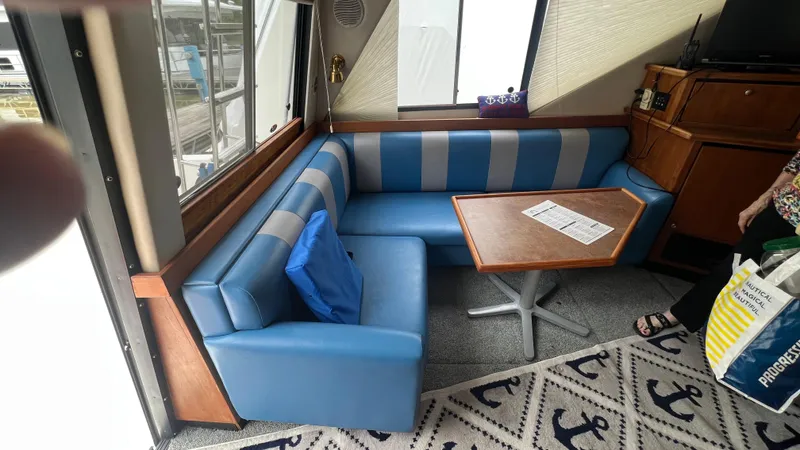 Slide: The Image of Interior of 1999 Bayliner 3988 Motoryacht with blue seating and wooden table. - 8