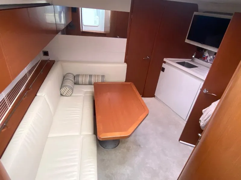 Slide: The Image of Interior of 2014 Beneteau 38 sailboat with dining area and kitchenette. - 13