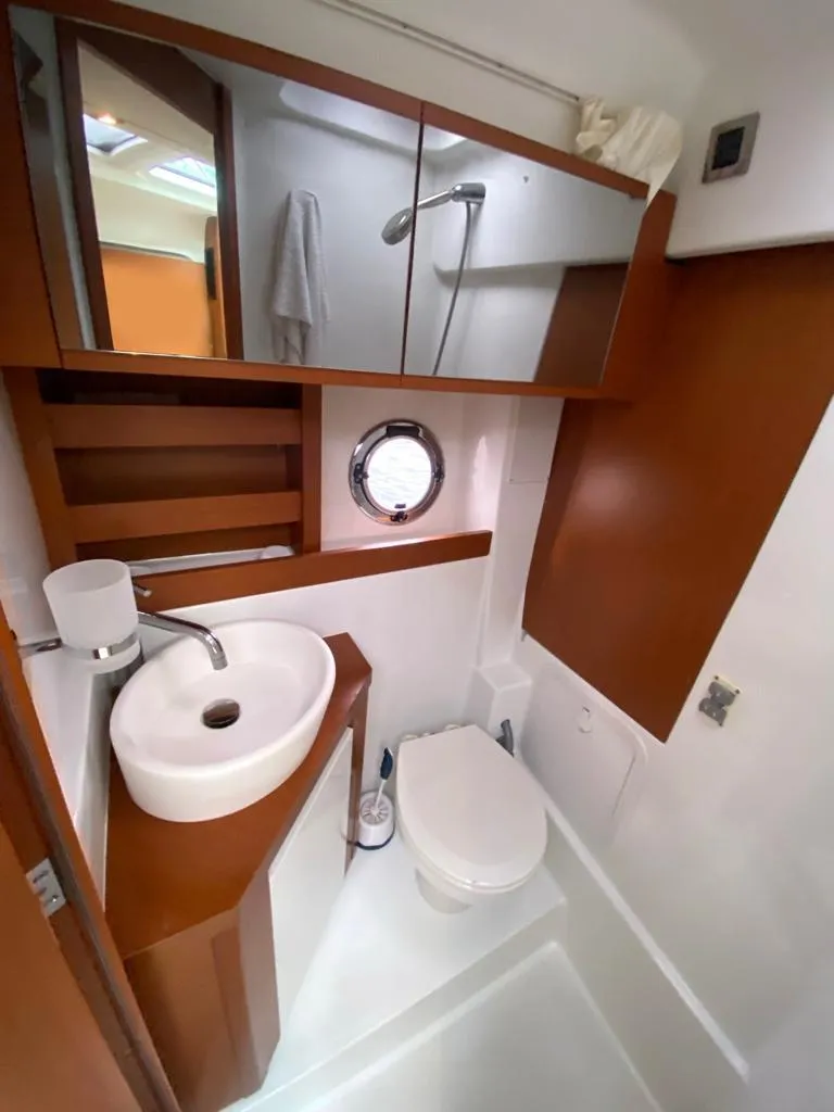 Slide: The Image of 2014 Beneteau 38 yacht bathroom with modern fixtures and wooden cabinetry. - 18