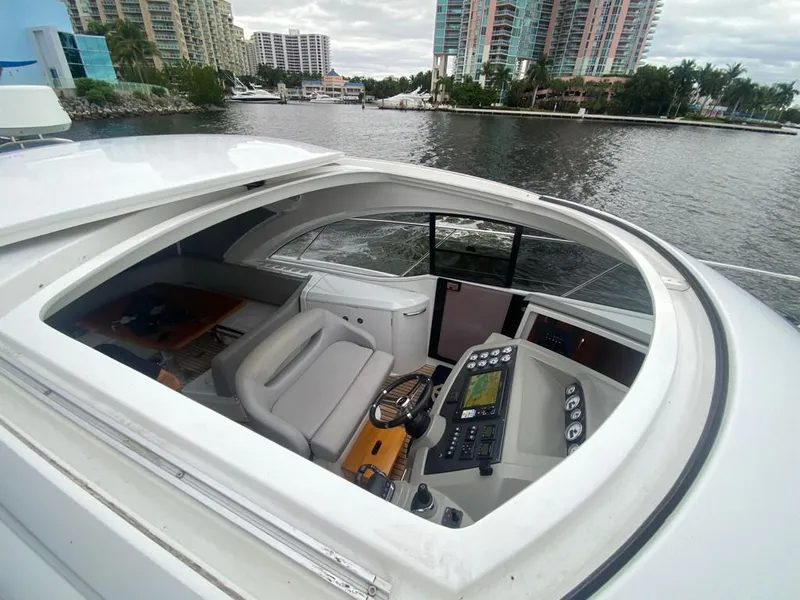 Slide: The Image of 2014 Beneteau 38 yacht cockpit with modern navigation controls, docked near waterfront buildings. - 4