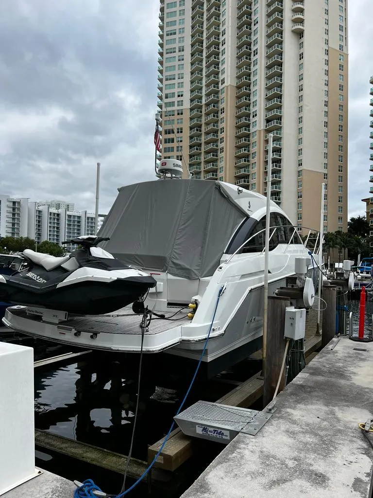 Slide: The Image of 2014 Beneteau 38 yacht docked at a marina with high-rise buildings in the background. - 5
