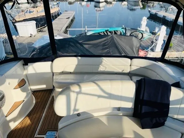 Slide: The Image of 2003 Regal 3860 Commodore yacht interior with white seating and marina view. - 10