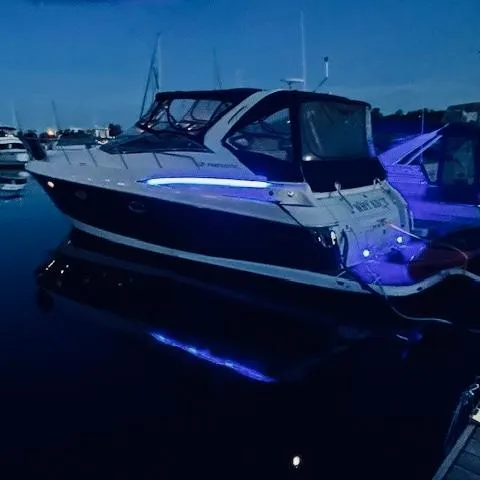 Slide: The Image of 2003 Regal 3860 Commodore yacht with blue LED lights docked at night. - 3
