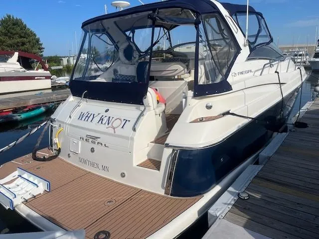 Slide: The Image of 2003 Regal 3860 Commodore boat docked, featuring "Why Knot" name on stern. - 4