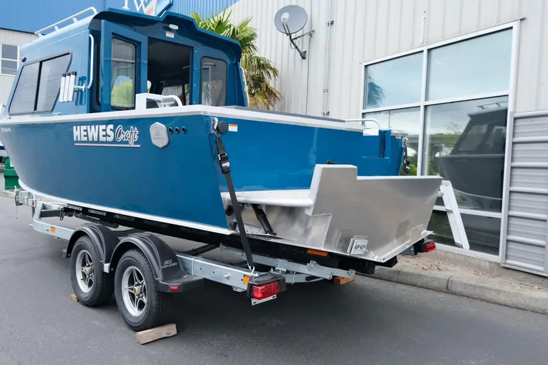 Slide: The Image of 2024 Hewescraft 220 Ocean Pro boat on trailer, blue exterior, parked near building. - 4