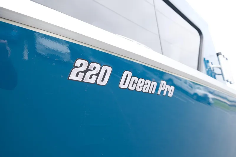 Slide: The Image of 2024 Hewescraft 220 Ocean Pro boat, blue exterior with model name displayed. - 6