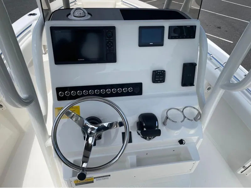 Slide: The Image of 2024 Key West 219 FS boat console with steering wheel, navigation screens, and controls. - 19