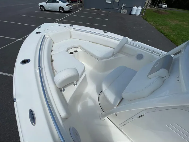 Slide: The Image of 2024 Key West 219 FS boat interior with white seating in a parking lot. - 23