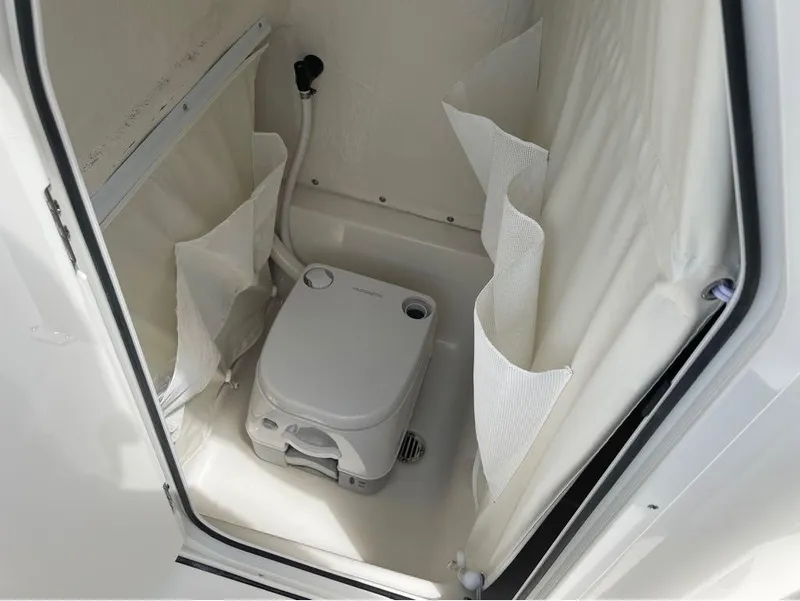 Slide: The Image of 2024 Key West 219 FS boat interior with portable toilet and storage pockets. - 29