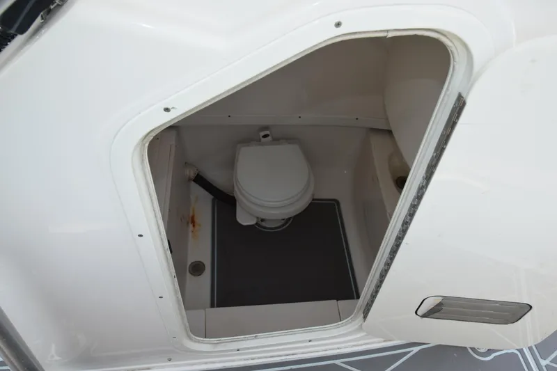 Slide: The Image of 2006 Robalo R260 Center Console boat interior with a built-in marine toilet. - 12