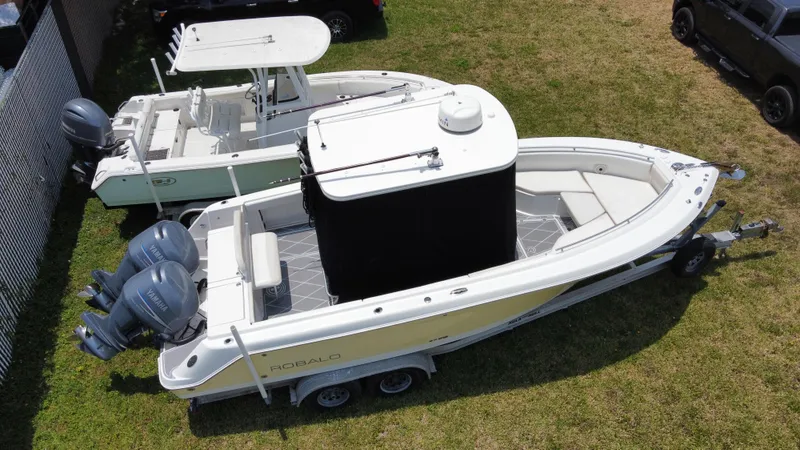 Slide: The Image of 2006 Robalo R260 Center Console boat with dual outboard engines on trailer. - 14