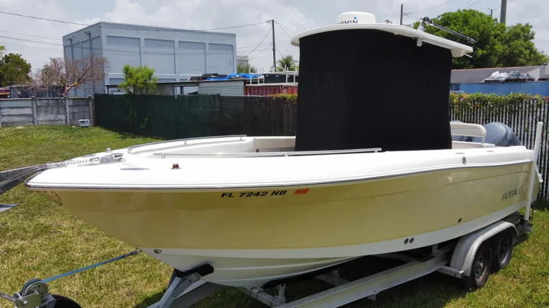 Slide: The Image of 2006 Robalo R260 Center Console boat on a trailer in a yard. - 2