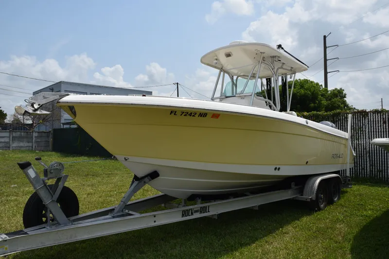 Slide: The Image of 2006 Robalo R260 Center Console boat on a trailer in a grassy area. - 3