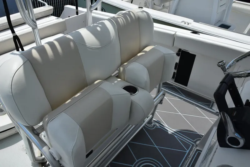 Slide: The Image of 2006 Robalo R260 Center Console boat seating area with cushioned seats and cup holders. - 38