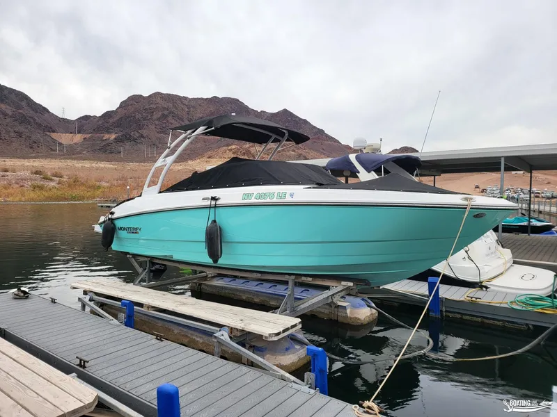 Slide: The Image of 2023 Monterey M22 boat docked on a lake with mountainous background. - 13